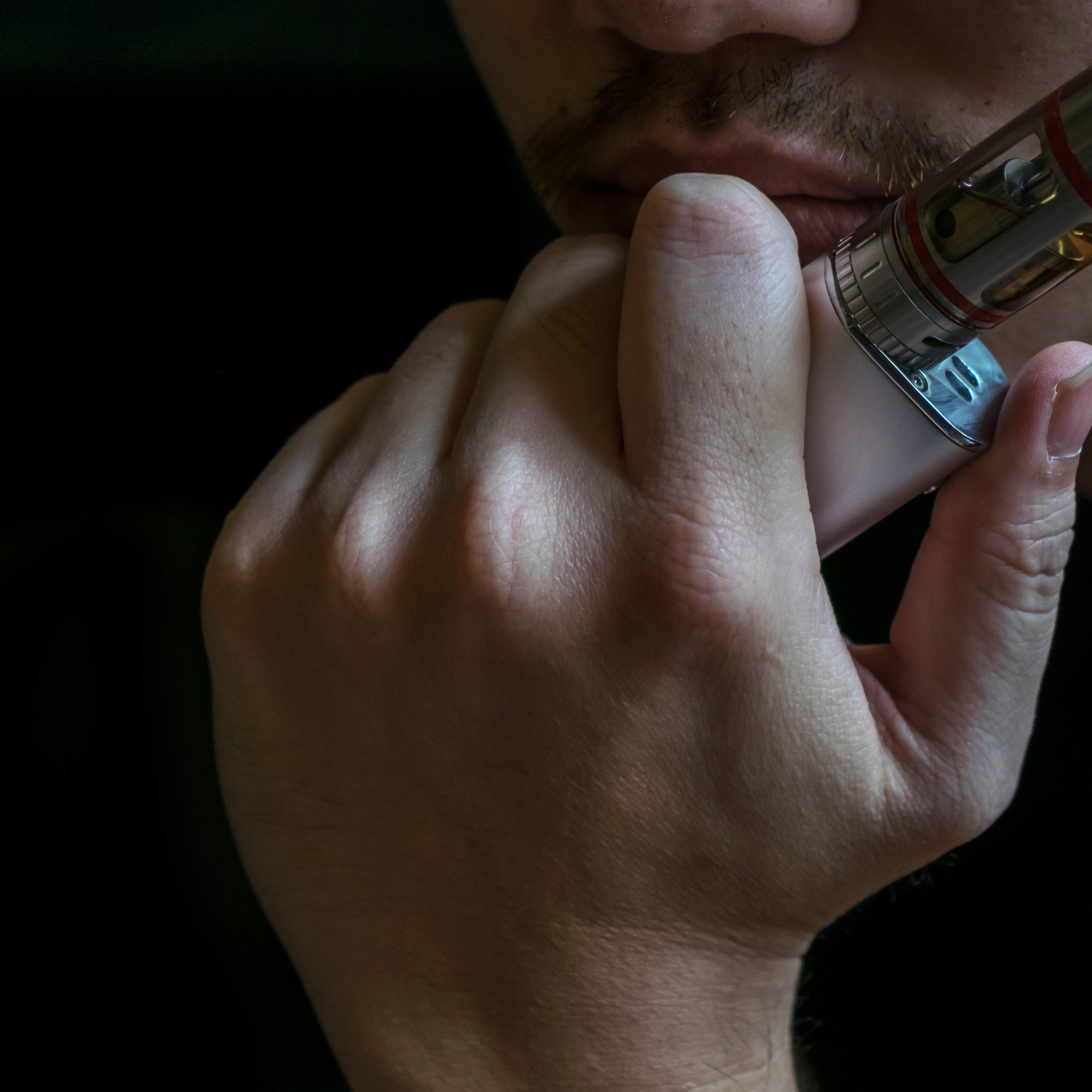 A man holding a vape to his face