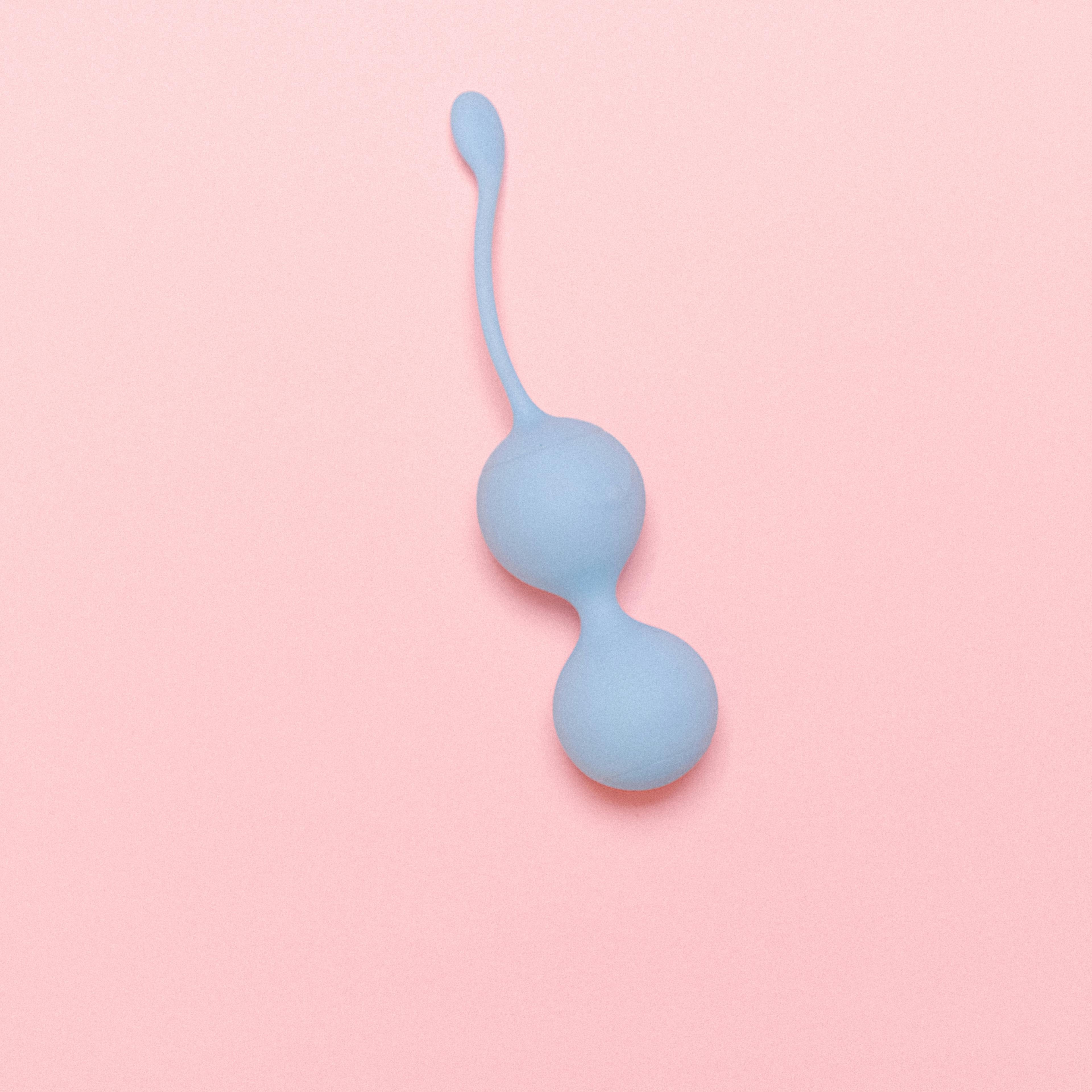 Blue Ben Wa Balls for women on a pink background