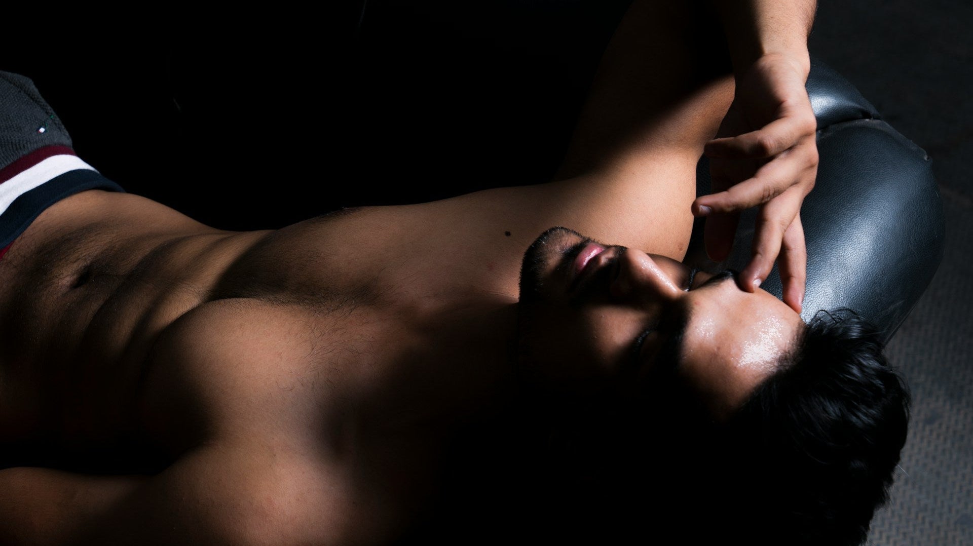 Shirtless male model posing on a chair