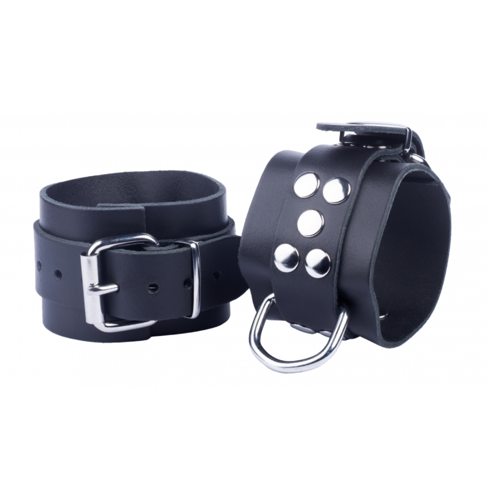 Black leather handcuffs with metal hardware from Luvland's Fuck & Fist collection, featuring adjustable straps and secure locking mechanism.