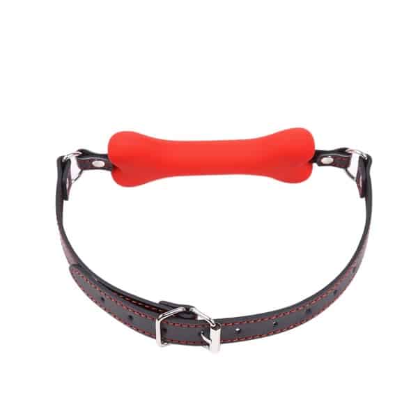 Red bone gag with black leather strap from Ideal Leather, showcasing adjustable straps and secure metal fittings on a plain background.