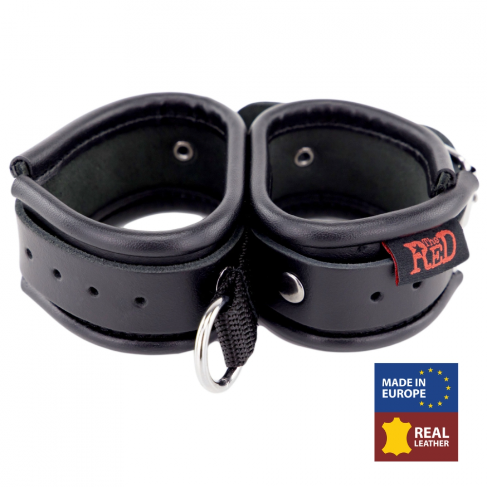 Black leather hand restraints from Fuck & Fist by Luvland, featuring adjustable straps and sturdy metal hardware for restraint and bondage play.