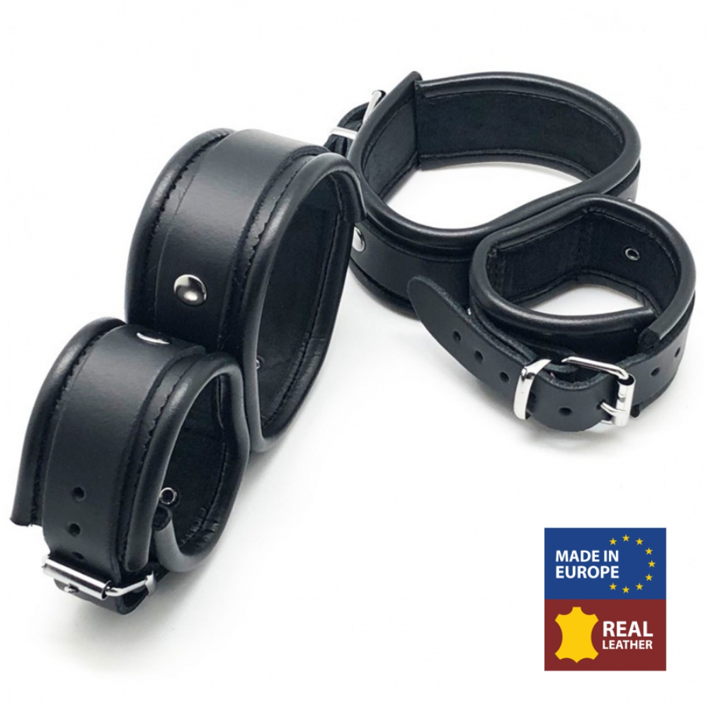Black leather ankle and hand cuffs from Luvland featuring sturdy straps and metal hardware for bondage restraint.