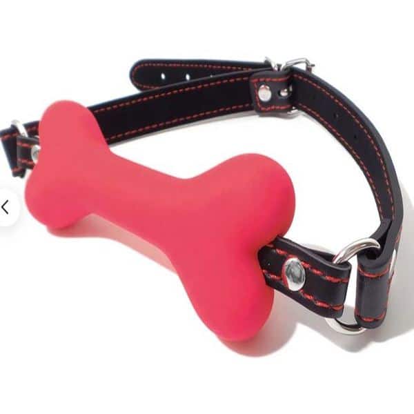 Red bone gag with black leather strap from Ideal Leather, featuring adjustable buckle and padded comfort for BDSM play.